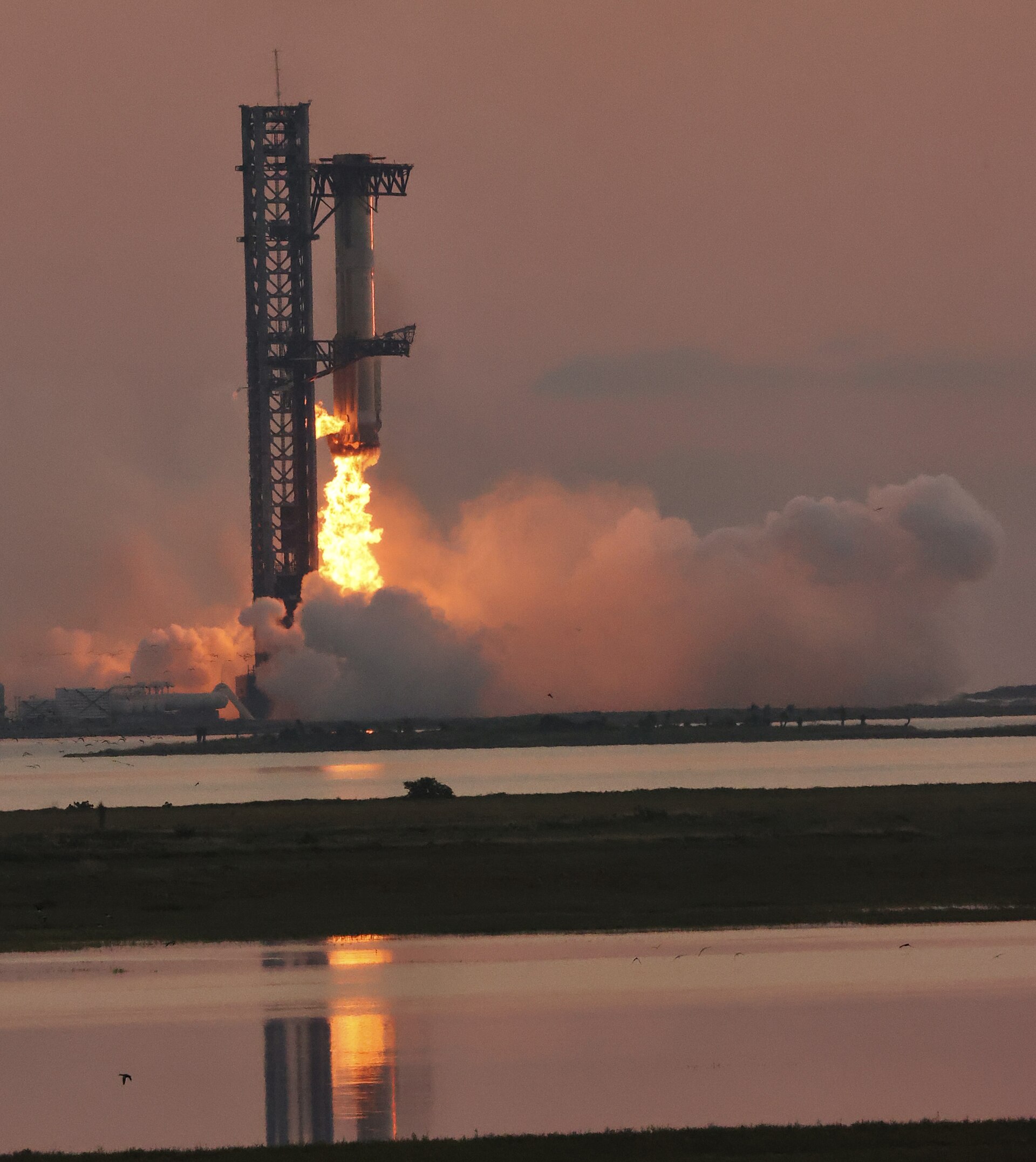 Super Heavy booster being caught by the Mechazilla launch tower arms during Starship Flight 5